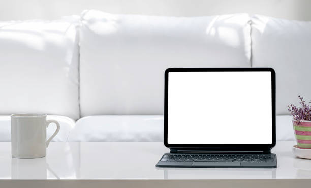 istock Blank screen tablet with keyboard on white table in living room. 1327259838