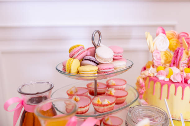 istock French macaroons on a cake stand .Candy bar with macaron, cakes, cheesecakes, cake pops.Colorful macaroons on serving tray.Decorative sweet birthday table in bright colors of yellow, white and pink. 1327259936