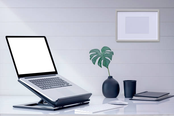 istock Mockup blank screen laptop computer on wooden stand with keyboard and mouse on white top table. 1327260127
