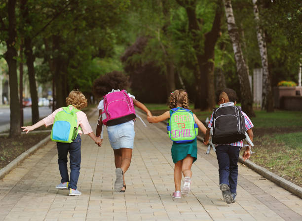small schoolchildren with colorful school bags and backpacks run to school. Back to schoo small schoolchildren with colorful school bags and backpacks run to school. Back to school, education, elementary school. back to schoo stock pictures, royalty-free photos & images