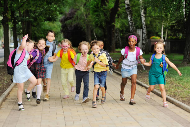 small schoolchildren with colorful school bags and backpacks run to school. Back to schoo small schoolchildren with colorful school bags and backpacks run to school. Back to school, education, elementary school. back to schoo stock pictures, royalty-free photos & images