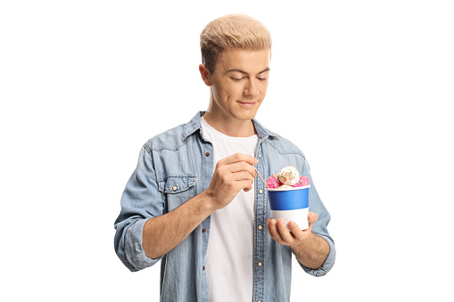 Guy eating an ice cream in a paper cup isolated on white background