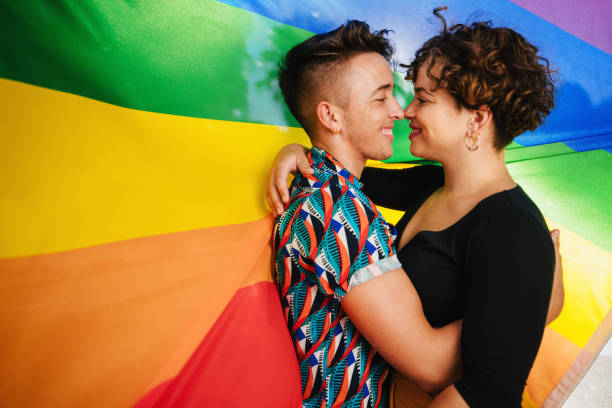 istock Romantic queer couple bonding against a rainbow flag 1327263100