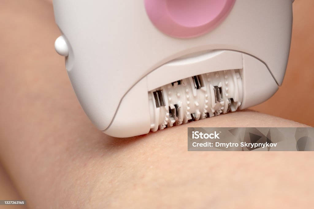 Skin Care and Health. Hair Removal. Woman Epilating Leg, White Electric Epilator. Skin Care and Health. Hair Removal. Woman Epilating Leg, White Electric Epilator Electricity Stock Photo