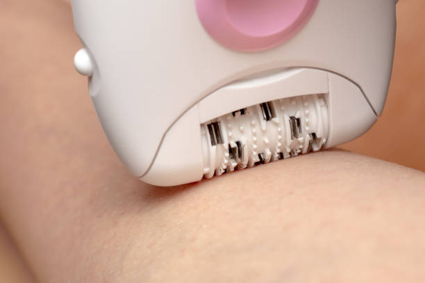 Skin Care and Health. Hair Removal. Woman Epilating Leg, White Electric Epilator. Skin Care and Health. Hair Removal. Woman Epilating Leg, White Electric Epilator epilator stock pictures, royalty-free photos & images
