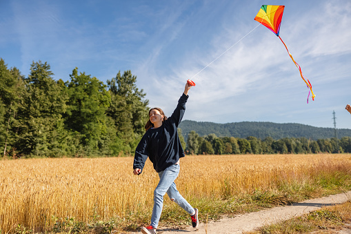 Adorable Little Girl Flying A Kite in The Meadow Outdoors