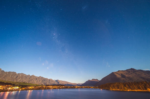 quartier d’affaires nocturne du centre-ville de queenstown, île du sud de la nouvelle-zélande. immobilier, logement et entreprise foncière avec belle vue naturelle autour avec ciel de la voie lactée - adventure business horizontal real estate photos et images de collection