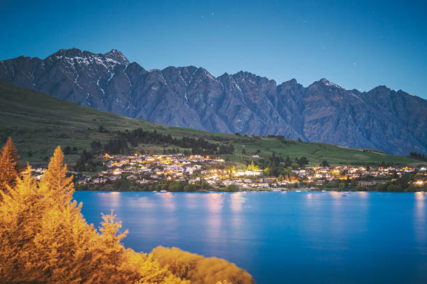 quartier d’affaires nocturne du centre-ville de queenstown, île du sud de la nouvelle-zélande. immobilier, logement et entreprise foncière avec belle vue naturelle autour avec ciel de la voie lactée - adventure business horizontal real estate photos et images de collection