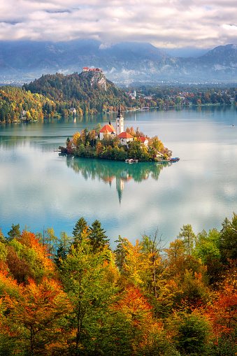 Famous alpine Bled lake (Blejsko jezero) in Slovenia, amazing autumn landscape. Aerial view of the lake, island with church, Bled castle and Julian Alps from Mala Osojnica, vertical travel background