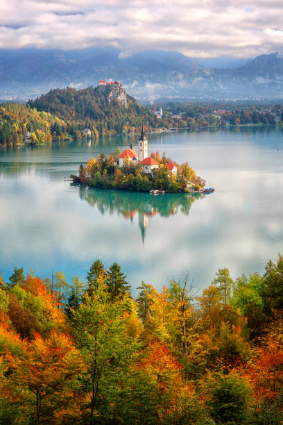 Famous alpine Bled lake (Blejsko jezero) in Slovenia, amazing autumn landscape. Scenic aerial view, outdoor travel background Famous alpine Bled lake (Blejsko jezero) in Slovenia, amazing autumn landscape. Aerial view of the lake, island with church, Bled castle and Julian Alps from Mala Osojnica, vertical travel background gorenjska stock pictures, royalty-free photos & images