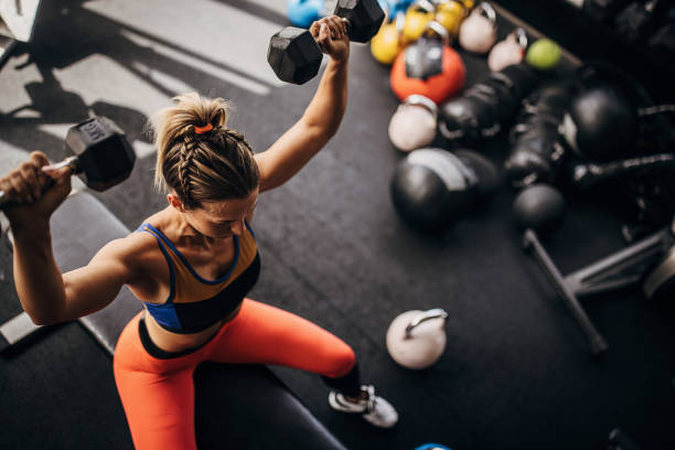 fit kobieta trenuje z hantlami - women weight bench exercising weightlifting zdjęcia i obrazy z banku zdjęć