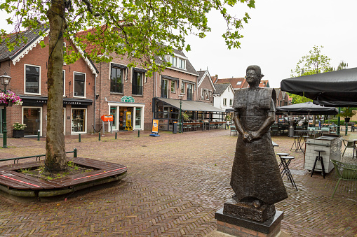 Spakenburg, Netherlands on June 30, 2021; Statue of a woman in traditional dress in the historic fishing village of Bunschoten-Spakenburg in the Netherlands.