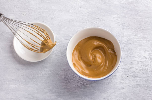 istock Ceramic bowl and whisk with fluffy creamy whipped coffee foam on a light gray textured background. For dalgona coffee, trendy food and drink concept 1327273769