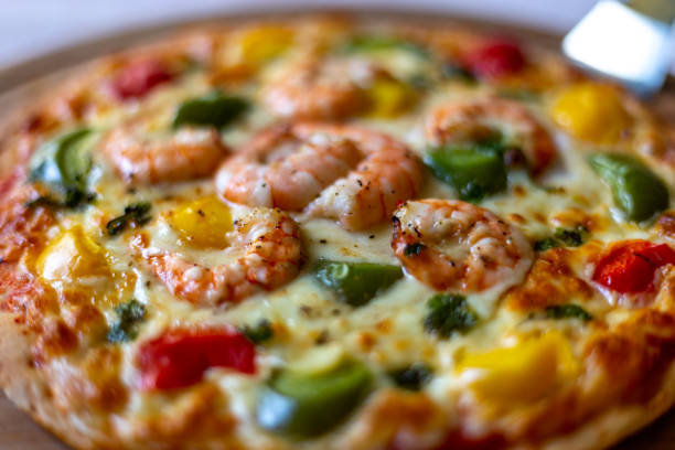 istock Grilled Shrimp Pizza on a wooden round cutting board 1327274735