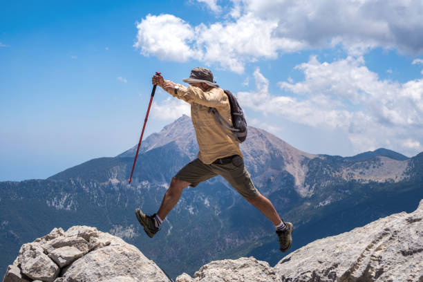 istock Male model with backpack jumping from boulder to boulder at high altitude 1327275107