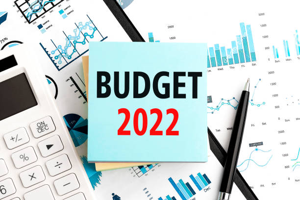 text budget 2022 on stickers. pen and calculator on clipboard with charts, documents and graphs. business plan. top view. - budget stok fotoğraflar ve resimler