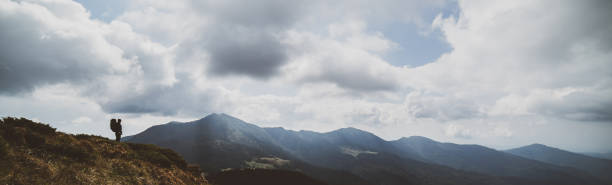 istock The man standing on the mountain on a cloud background 1327276308