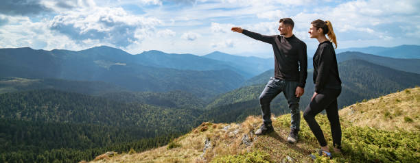 istock The couple gesturing on the mountain with a picturesque cloudscape 1327276330