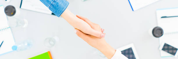 istock The two people handshake at the desktop. view from above 1327276908