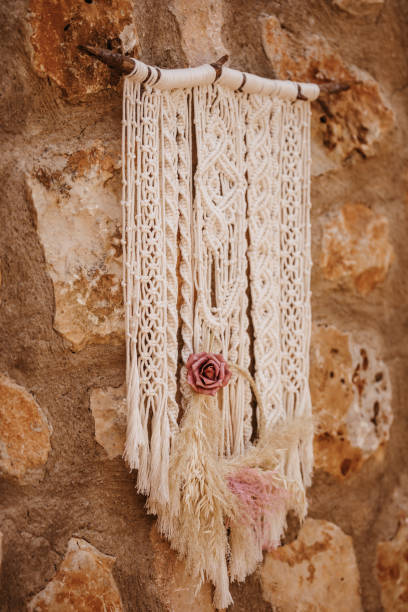 istock Selfmade beige boho macrame wall hanger with a pastel pink rose 1327276934