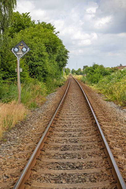 istock Single track railroad crossing through an area with low trees 1327277735
