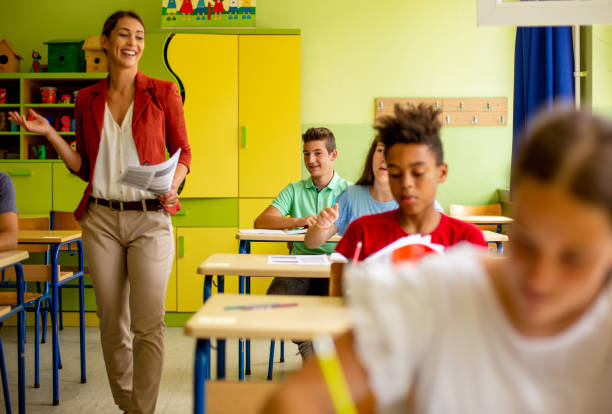 istock Teacher giving kids tests. 1327278035