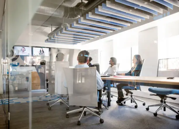 Business team sitting inside conference room and having a video conference in office