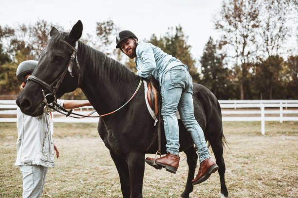 istock Female Stabilizing Horse So Male Student Can Climb It 1327278954