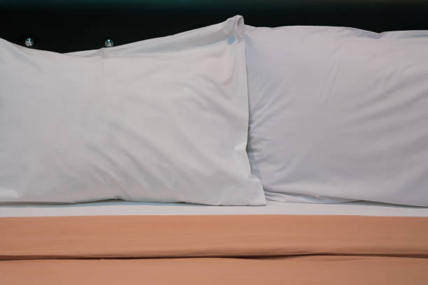 istock Two big white pillows on a white bed. Close up 1327280728