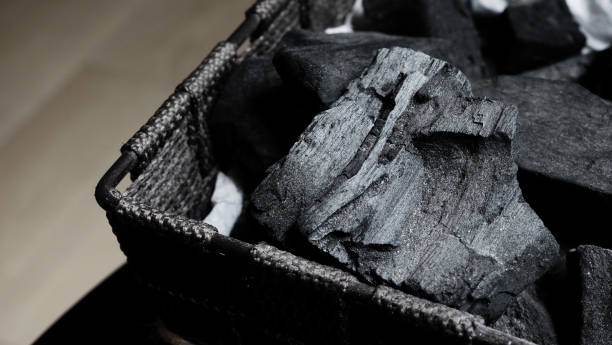 istock Black Charcoal on black textured floor. charcoal black carbon reesidue produced by strongly heating wood. Used for cooking or other industries. Natural wood charcoal. traditional hard wood charcoal. 1327282022