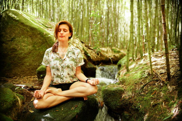 istock Young woman meditating on a rock in a bamboo grove 1327282096