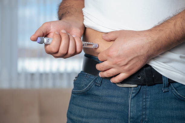 istock Man is injecting insulin into his stomach 1327284078