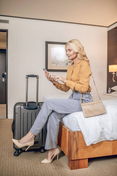 istock Blonde elegant woman with a smartphone in hands 1327285807