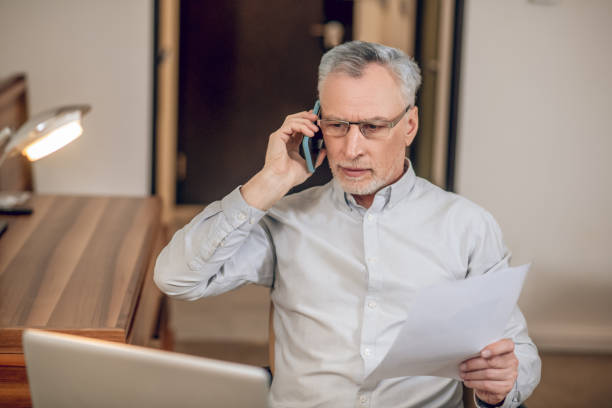 istock Mature man talking on the phone and looking involved 1327285870