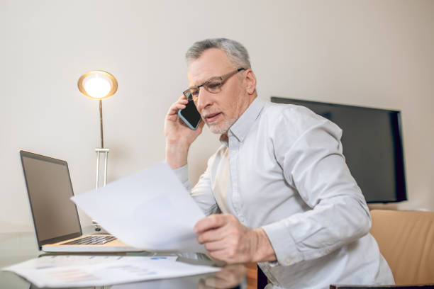 istock Mature man talking on the phone and looking involved 1327285880