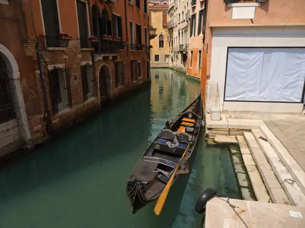 Narrow canal with bridge and gondola in Venice, Italy. Architecture and landmark of Venice