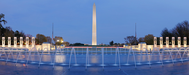 Nighttime panoramic view of the Washington monument and the World War II Memorial located on the National Mall in Washington DC.