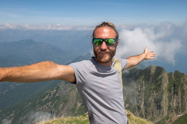 istock Cheerful young man taking a selfie portrait on mountain top 1327293439