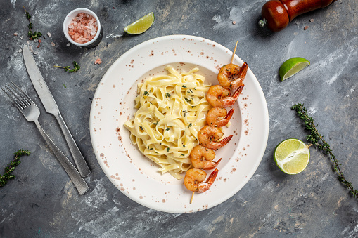 Italian pasta fettuccine in a creamy sauce with shrimp. banner, menu recipe place for text, top view.