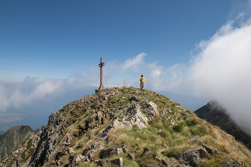 Hiker female walks on top of mountain. Ticino canton, Switzerland