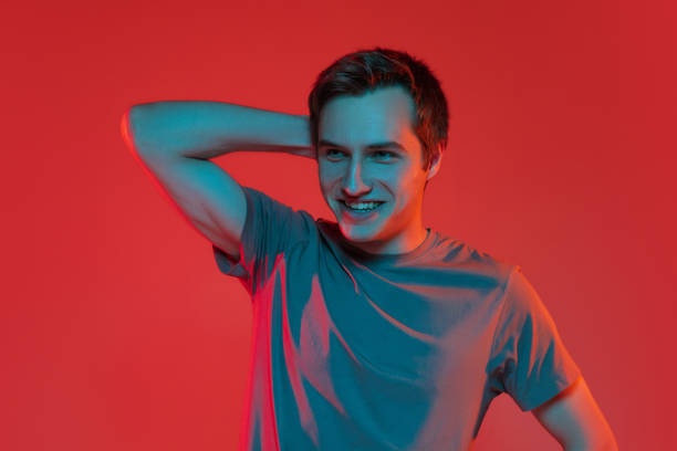 istock One young smiling handsome caucasian guy isolated on red neon background. Concept of human emotions, facial expression. 1327298331
