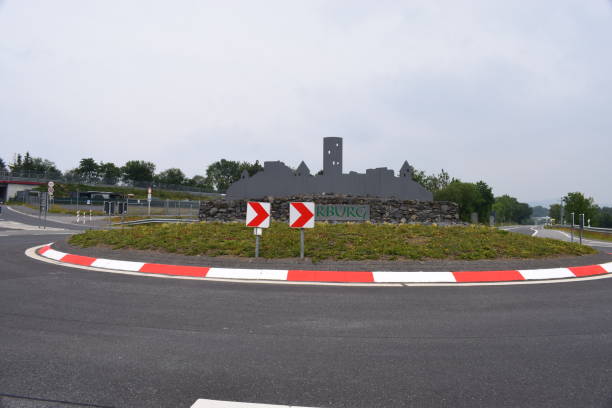 roundabout at the entry of Nürburg with villagescape Nürburg, Germany - 06/09/2020: roundabout at the entry of Nürburg with villagescape nürburgring stock pictures, royalty-free photos & images