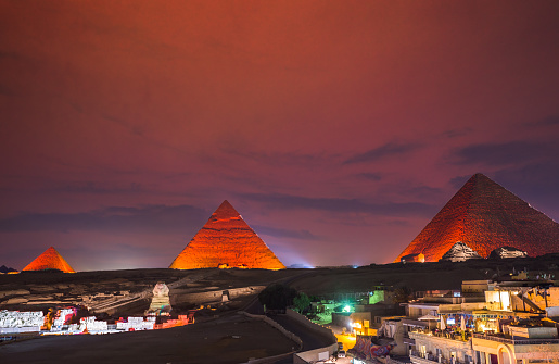 Illuminated egyptian pyramids at sunset in Cairo