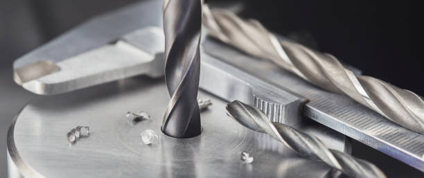 istock drill bit make holes in steel billet on industrial drilling machine with ruler and caliper. Metal work industry. multi cutting tool and end mill. 1327302335