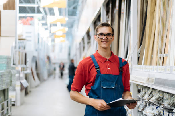 smiling floor covering store consultant with a clipboard standing in the sales area stock photo