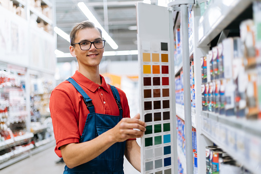 close-up. smiling construction store clerk standing near the color palette samples .