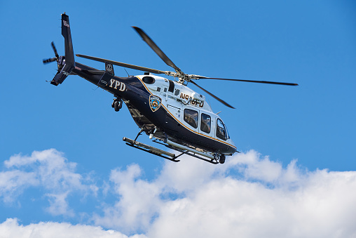 New York, NY - June 23, 2021: A New York City Police Bell 429 Helicopter as it takes off from a heliport in Lower Manhattan, NYC. The Bell 429 was designed for EMS work with rear clamshell doors to make loading patients easier.