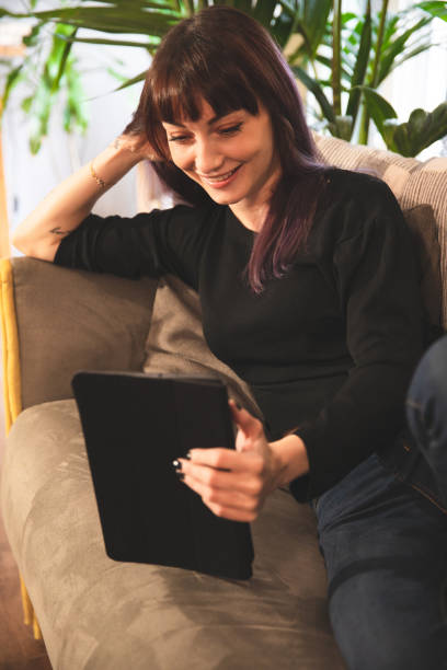 istock Woman at home uses the tablet on the sofa 1327306794