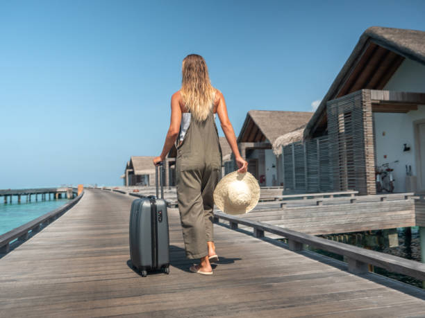 istock Woman pulls trolley on wooden pier in tropical destination 1327307603