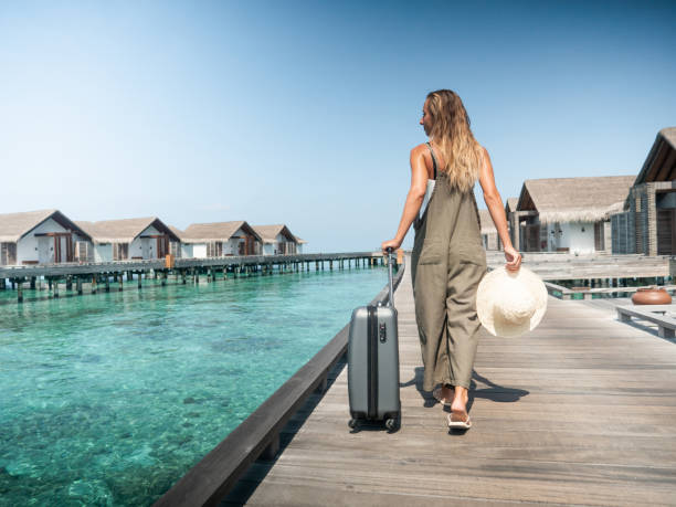 istock Woman pulls trolley on wooden pier in tropical destination 1327308398